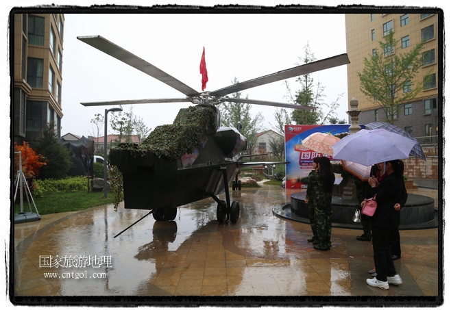 小區(qū)突然出現(xiàn)“飛機(jī)坦克”，其中殲15艦載戰(zhàn)斗機(jī)一架、99式主戰(zhàn)坦克一輛、武直-10武裝直升機(jī)一架，吸引了眾多市民雨中圍觀、合影。